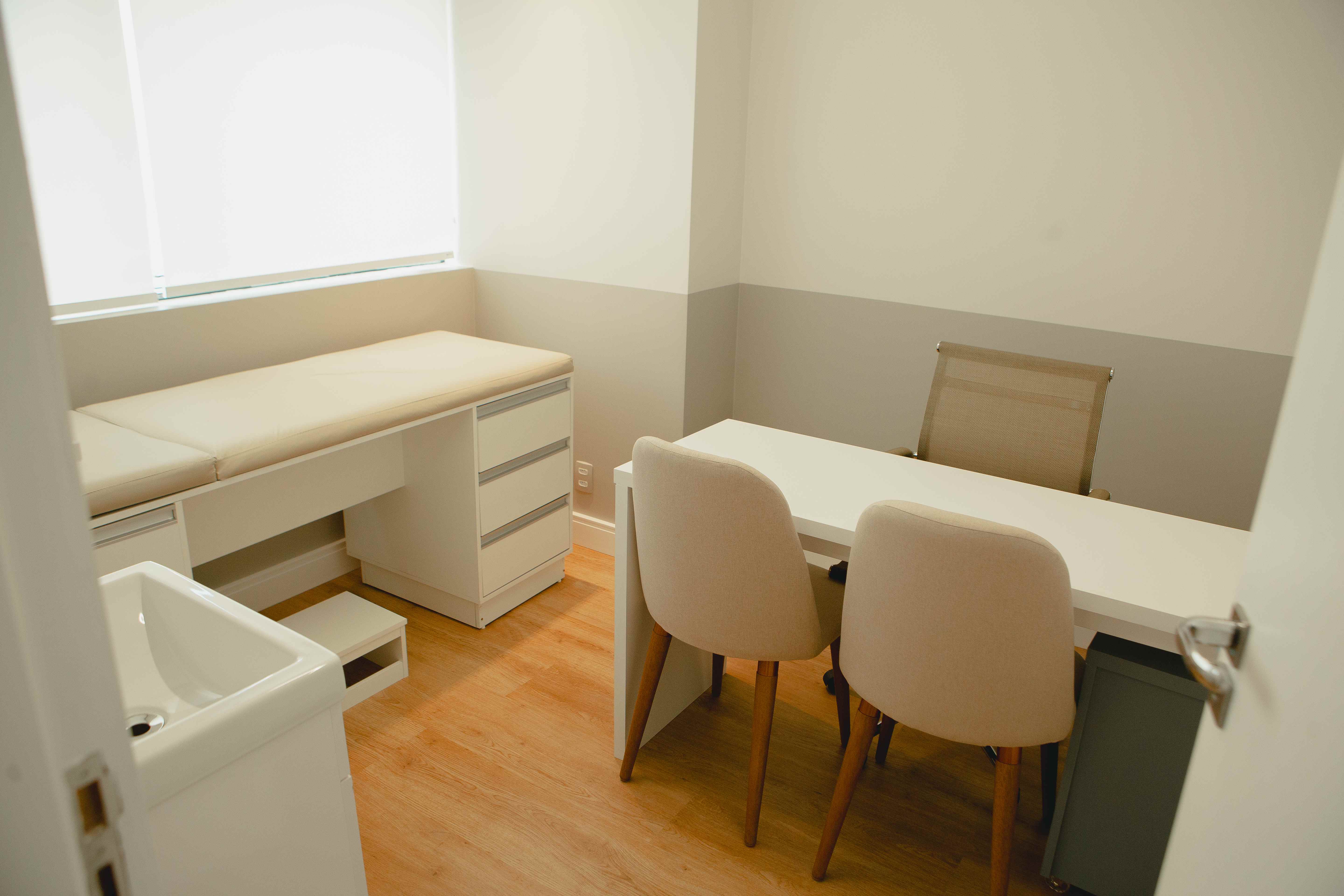 Sala de consulta com mesa e maca